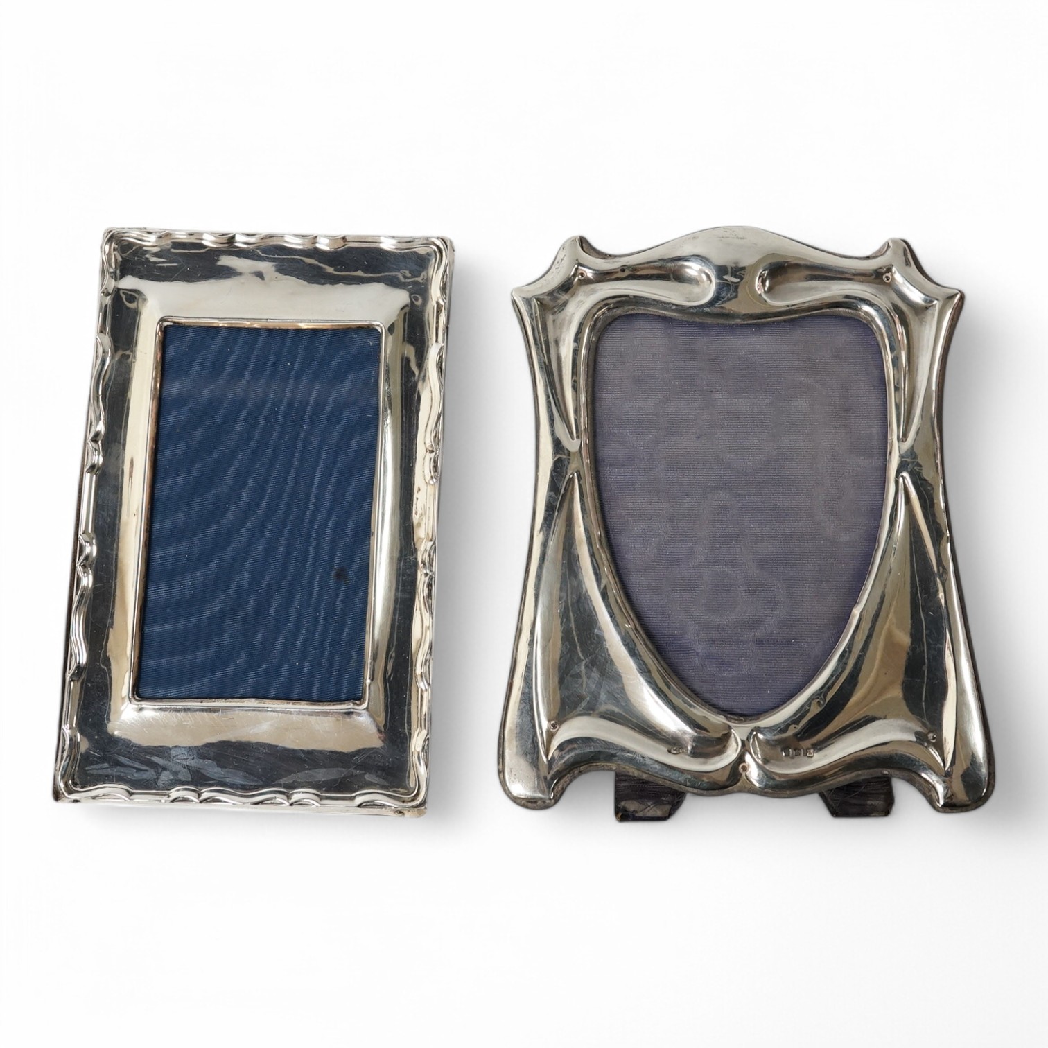 An Edwardian Art Nouveau silver mounted photograph frame, by Sydney & Co, Birmingham, 1907, 19cm, together with a later George V silver mounted photograph frame. Condition - fair